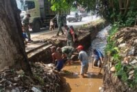 Foto : anggota dari Koramil 0819/14 Gondang Wetan Pasuruan. Bersama warga bersihkan parit