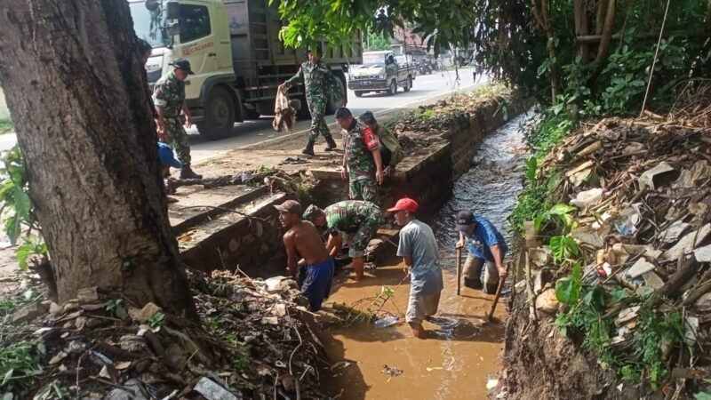 Foto : anggota dari Koramil 0819/14 Gondang Wetan Pasuruan. Bersama warga bersihkan parit