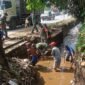 Foto : anggota dari Koramil 0819/14 Gondang Wetan Pasuruan. Bersama warga bersihkan parit