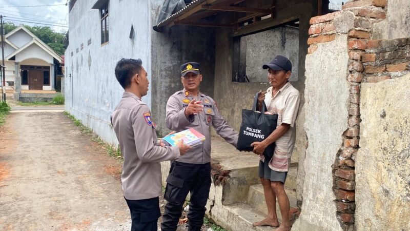 Foto : Kapolsek Tumpang AKP Achmad Zainuddin saat memberikan bantuan sembako 
