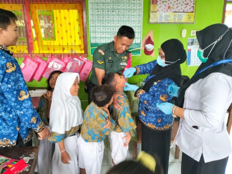 Foto : Babinsa Koramil 03/Kraton, Serda Didit Zulianto, bersinergi dengan bidan desa setempat menggelar Pekan Imunisasi Nasional (PIN) Polio