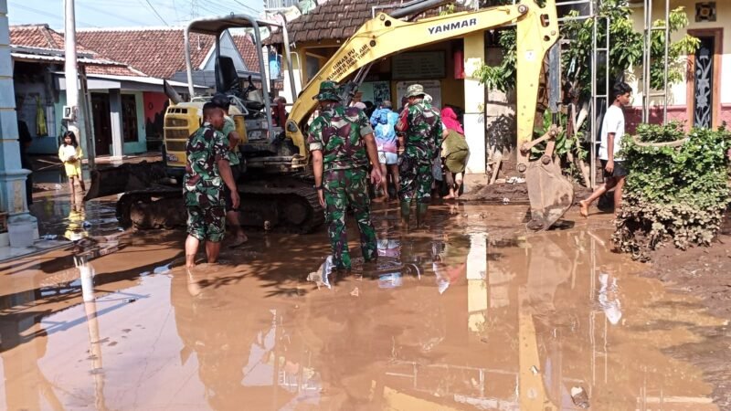 Foto : Personil Koramil 0819/15 Winongan bersama dengan BPBD dan masyarakat masih terus melakukan  pembersihan lumpur dan material denga alat berat