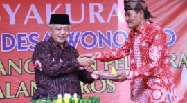 Caption. Bupati Malang H.M Sanusi saat memberikan potongan tumpeng pada Kepala Desa Wonorejo Singosari 
