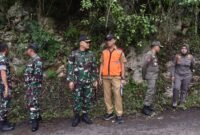Caption. Kepala Dinas Pekerjaan Umum dan Bina Marga Kabupaten Malang Khairul Isnaidi Kusuma (rompi oranye) saat berkoordinasi dengan anggota TNI dalam penanganan bencana longsor di Rajekwesi Desa Tumpakrejo Kecamatan Kalipare 