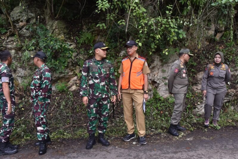 Caption. Kepala Dinas Pekerjaan Umum dan Bina Marga Kabupaten Malang Khairul Isnaidi Kusuma (rompi oranye) saat berkoordinasi dengan anggota TNI dalam penanganan bencana longsor di Rajekwesi Desa Tumpakrejo Kecamatan Kalipare 