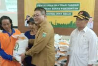 Caption. Wakil Bupati Malang Didik Gatot Subroto saat disaksikan Menteri koordinator Bidang Pembangunan Manusia dan Kebudayaan Muhadjir Effendy saat memberikan bantuan beras pada warga Desa Mulyagung Kecamatan Dau 