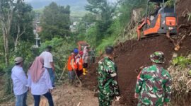 Foto : Anggota Polres Maang bersama TNI dan warga bersikan material tanah longsor