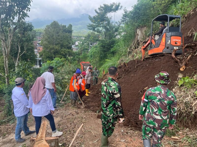 Foto : Anggota Polres Maang bersama TNI dan warga bersikan material tanah longsor