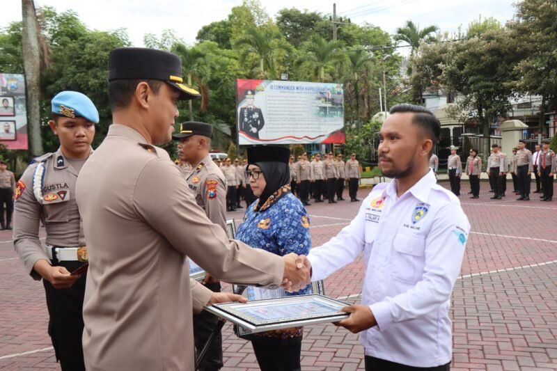 Foto : , Kapolres Malang, AKBP Putu Kholis Aryana berikan penghargaan kepada pengurus IMI, Andika Fajar Kurniawan dan Dony DKMS. 