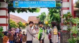 Foto: Kanit Binmas dan Bhabinkantibmas Polsek Tumpang berikan Rmpi ke Satpam SD Negeri 1 Tumpang