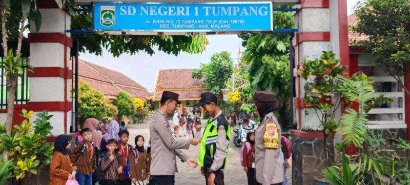 Foto: Kanit Binmas dan Bhabinkantibmas Polsek Tumpang berikan Rmpi ke Satpam SD Negeri 1 Tumpang