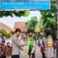 Foto: Kanit Binmas dan Bhabinkantibmas Polsek Tumpang berikan Rmpi ke Satpam SD Negeri 1 Tumpang