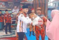 Foto : Ketua PAC Pemuda Pancasila PP Dampit Nanang Qosim memberikan sembako kepada warga 