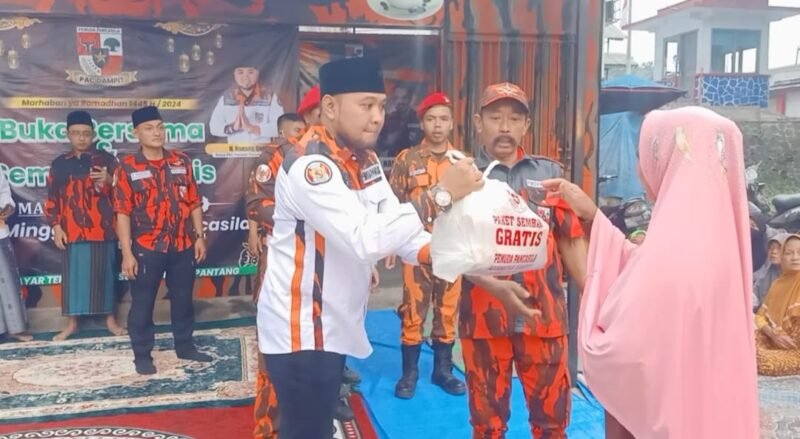 Foto : Ketua PAC Pemuda Pancasila PP Dampit Nanang Qosim memberikan sembako kepada warga 