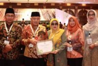 Caption. Bupati Malang H.M Sanusi didampingi Ketua TP PKK kabupaten Malang Aniz Zaida Sanusi dan Ketua BAZNAS Kabupaten Malang serta OPD usai menerima penghargaan BAZNAS Award 2024