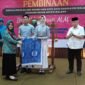 Ket foto. Ketua Tim Penggerak PKK kabupaten Malang Anis Zaida Sanusi saat memberikan secara simbolis batik pelajar Garudeya disaksikan Bupati Malang H.M Sanusi, Kepala Dinas Pendidikan Suwadji dan Ketua MKKS SMPN Suntoro