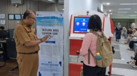 Ket foto. Dibantu petugas Dispendukcapil Kota Malang,  salah satu warga sedang mengakses layanan administrasi kependudukan lewat ADM 