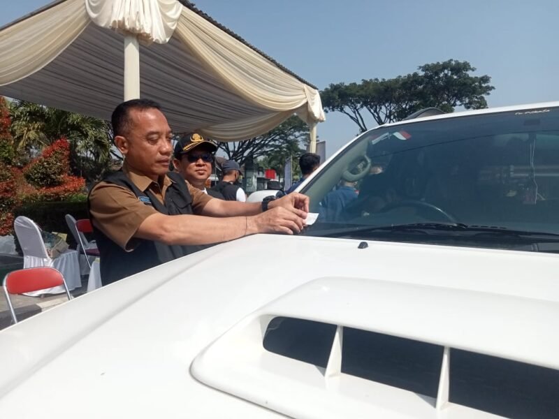 Foto : Sekretaris Dinas Lingkungan Hidup Kota Malang, Soni Bachtiar menempelkan stiker pada kendaraan yang lolos uji emisi gas buang