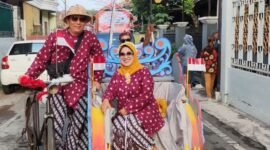 Foto : Bu RW 15 Intiarni Hadi Sumanto menaiki becak dengan maskot Garuda bersama Ketua RW 15 Kelurahan Lowokwaru Hadi Sumanto