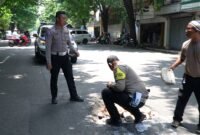 Ket foto. Petugas Kepolisian Resor Pasuruan saat memperbaiki jalan yang berlubang 
