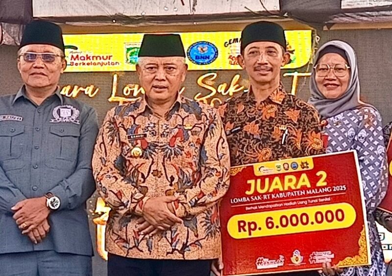 Ket foto. Bupati Malang H.M Sanusi bersama Kepala Desa Tirtomoyo Pakis usai memperoleh penghargaan sebagai juara ke II dalam Lomba SAK-RT di Desa Sukoanyar Wajak