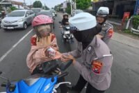 Dokumen foto : satlantas saat memberikan susu kepada anak sekolah dan pengendara