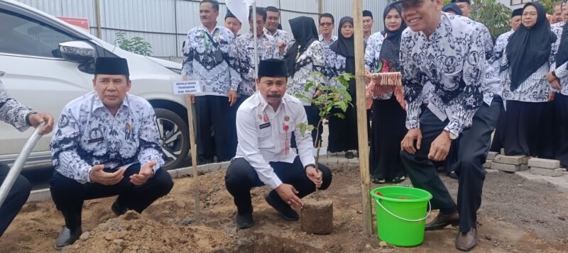 Ket foto. Kepala Dinas Pendidikan Kabupaten Malang, Suwadji saat melakukan penanaman pohon di halaman belang gedung PGRI 