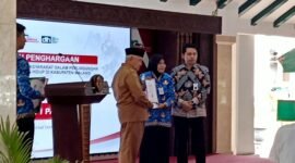 Ket foto. Bupati Malang H.M Sanusi didampingi Plt Kepala Dinas Lingkungan hidup saat menyerahkan  penghargaan lingkungan hidup pada Kepala Sekolah SMPN I Pakis, Dra. Nurus Solehati