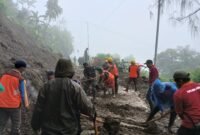 Ket foto. Tim gabungan membersihkan longsoran yang menutupi akses jalan