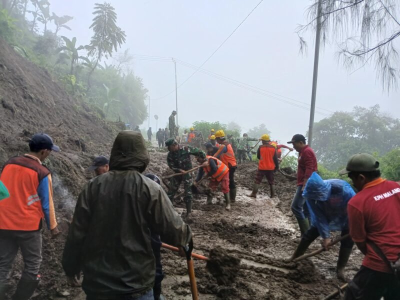 Ket foto. Tim gabungan membersihkan longsoran yang menutupi akses jalan