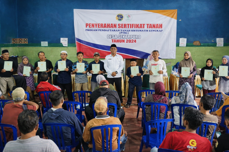 Ket foto. Kepala Desa Sekarpuro, Sulirmanto saat pembagian sertifikat tanah program PTSL di Balaidesa
