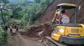 Ket foto. Alat berat dikerahkan untuk membersihkan longsoran tanah yang menutupi jalan di Desa Dalisodo Wagir