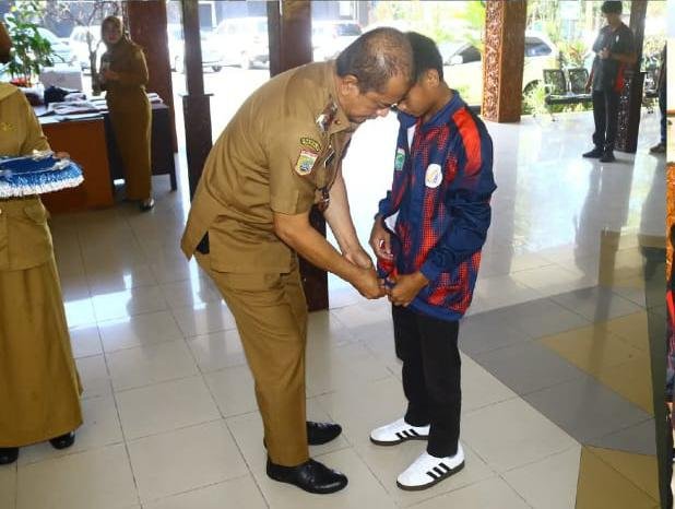 Kepala Dinas Pendidikan Kabupaten Malang, Bagus Sulistyawan, AP., M.Si Saat Pakaikan Rompi Ke Peserta Atlet O2SN (Foto: bgs Pendoposatu)