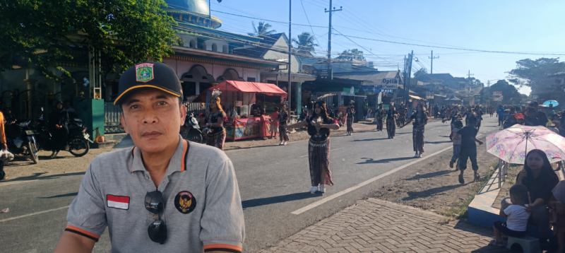 Ket foto. Ket foto. Kepala Desa Sidorejo, Pagelaran Kabupaten Malang, M. Hery Junaedi (insert) dengan latar belakang kirab 